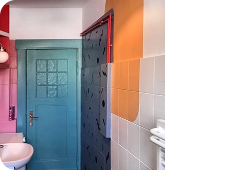 Colorful bathroom with pastel walls, sink, mirror, and turquoise door.